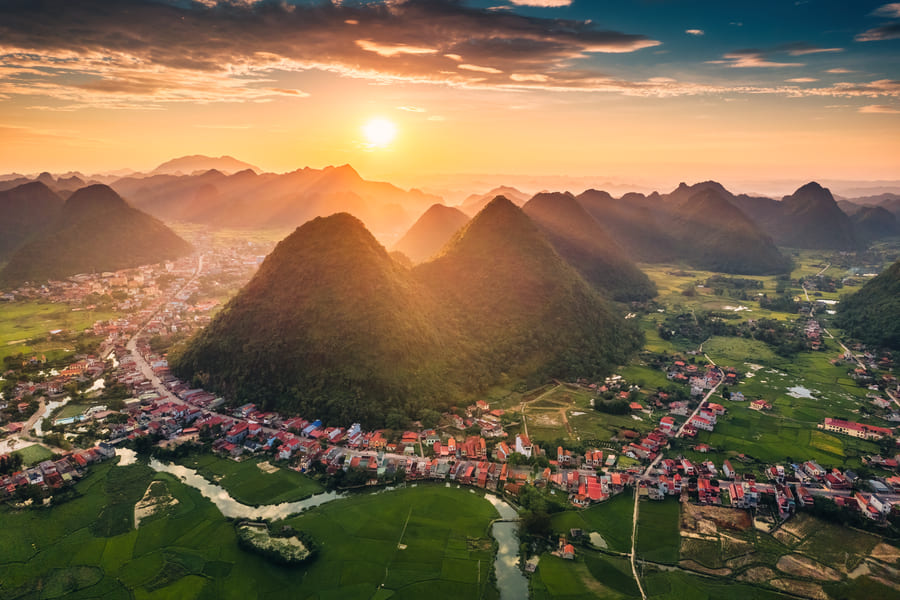 Ciudad con montaña en el centro y atardecer