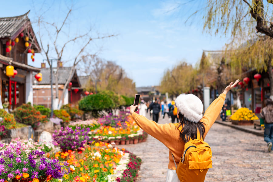 mujer con gorro en las calles con flores en la ciudad de china